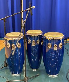 three large blue drums sitting on top of a table next to a microphone and other musical equipment