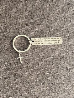 a keychain with a bible verse hanging from it's side on a carpeted floor