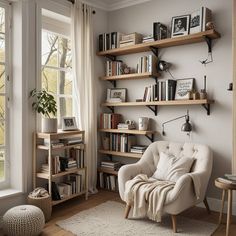 a living room filled with furniture and bookshelves next to a window covered in curtains