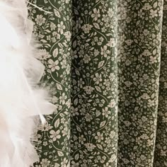 green and white floral curtains with feathers hanging from them