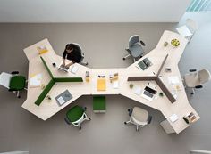 an overhead view of a table with chairs and laptops on it, in the middle of a room