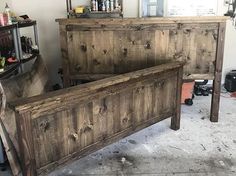 an old wooden bed frame in a room with other items on the walls and floor