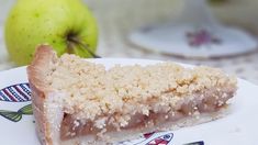 a piece of cake sitting on top of a white plate next to an green apple