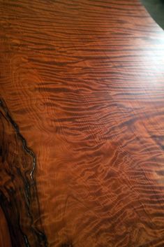 a close up view of a wooden table with wavy woodgrain on it's surface