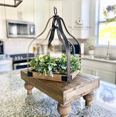 a candle sits on top of a wooden tray with succulents in it