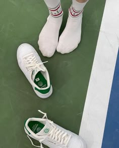 the tennis player's shoes are white and green