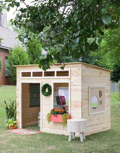 a small wooden shed sitting on top of a lush green field