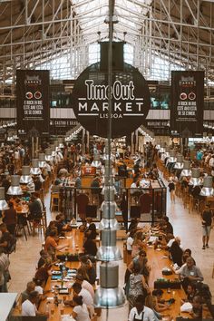 an indoor market with lots of tables and people eating