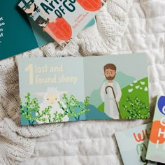 three children's books laying on top of a white blanket next to each other