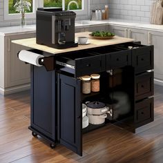 a small kitchen island with a coffee maker on it's top and drawers underneath