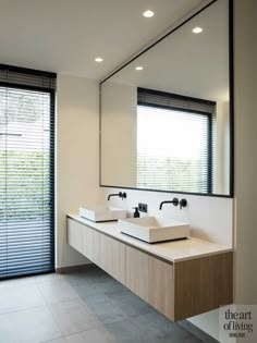 a modern bathroom with two sinks and mirrors