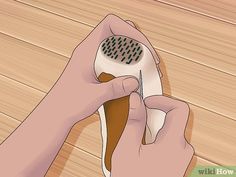 a person using a hair dryer on top of a wooden floor with their hands