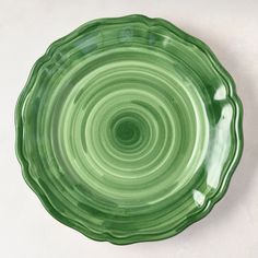 a green plate sitting on top of a white table