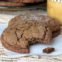 two chocolate cookies on a plate with one broken in half