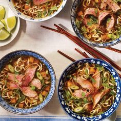 three bowls filled with meat and noodles next to chopsticks on a tablecloth