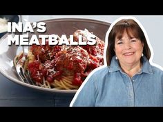 a woman standing in front of a plate of spaghetti and meatballs with the words ina's meatballs on it