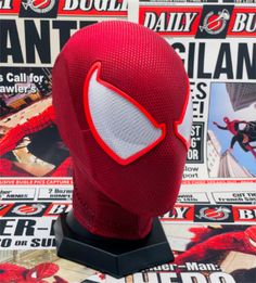 a spiderman mask is on display in front of a newspaper