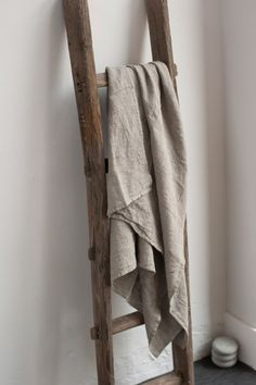 an old ladder leaning against the wall with a towel hanging on it's side