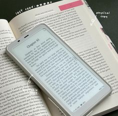 an electronic device sitting on top of an open book