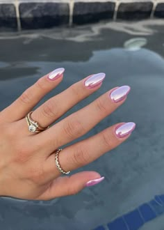 a woman's hand with pink and white manicured nails, ring on her finger