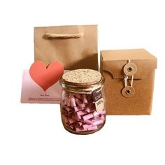 a jar filled with pink marshmallows next to a brown bag