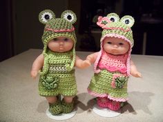 two crocheted dolls standing next to each other on top of a countertop