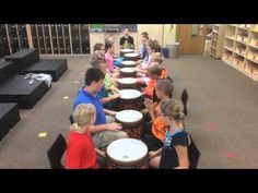 a group of children playing drums in a library