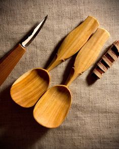 three wooden spoons and a brush on a table