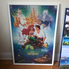 the little mermaid movie poster is next to other disney movies on display in their home