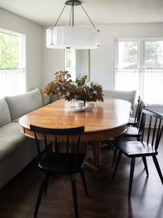 a dining room table with four chairs and a bench in front of the couches