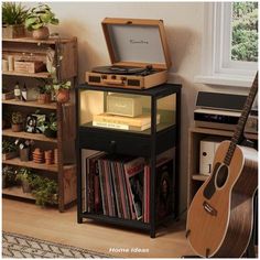 a record player sitting on top of a shelf next to a guitar