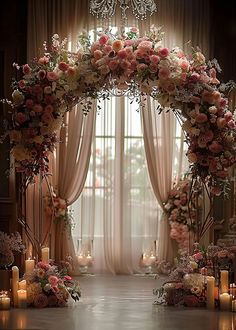 a wedding arch with flowers and candles in front of a window filled with drapes