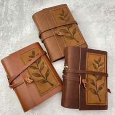 three brown leather journals sitting on top of each other