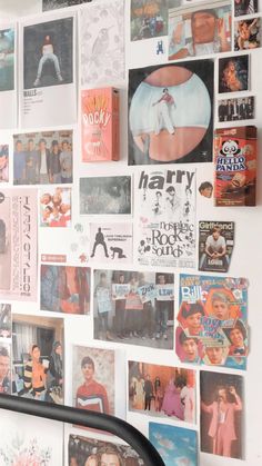 a white wall covered in posters and pictures