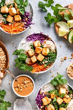 three bowls filled with different types of food and garnished with green leaves on the side