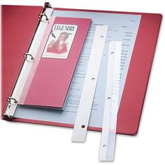 a red binder is open on top of a book with two white strips sticking out of it