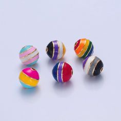 several different colored beads on a white surface with one being turned upside down to the side