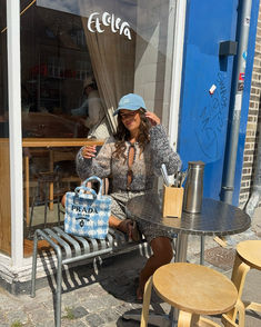 a woman sitting on a bench in front of a store