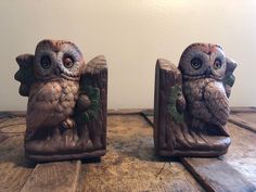 two owl figurines sitting on top of a wooden table