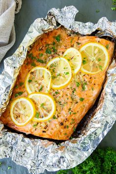 baked salmon with lemons and parsley on aluminum foil