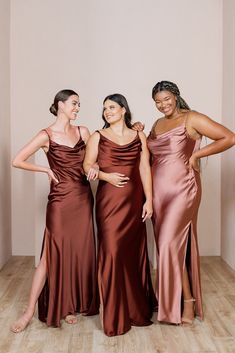 three women standing next to each other in dresses