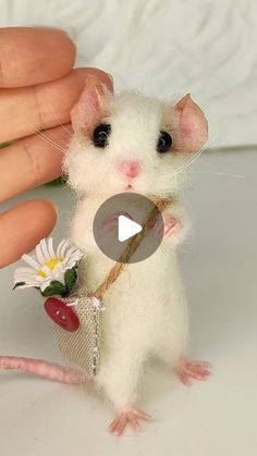 a tiny mouse holding a flower in its hand