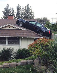 a car is upside down on the roof of a house that says, wait a second this isn't my roof