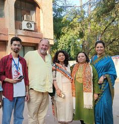 a group of people standing next to each other in front of a tall brick building