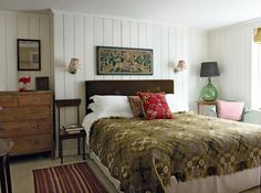 a bed sitting in a bedroom next to two lamps on either side of the bed