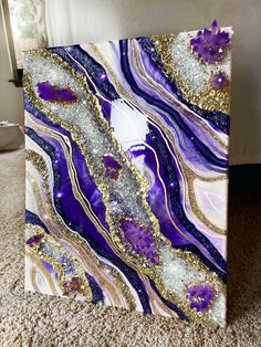 an abstract painting with purple, gold and white colors