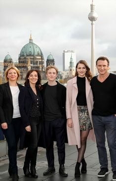 a group of people standing next to each other in front of a cityscape