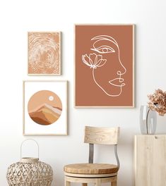 three framed art pieces hang on the wall above a chair and vase with flowers in it