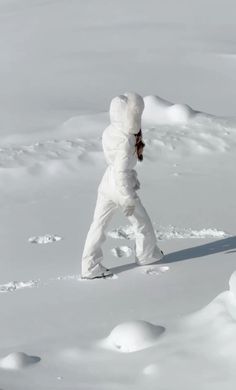 a person on skis in the snow with their back to the camera and arms behind them