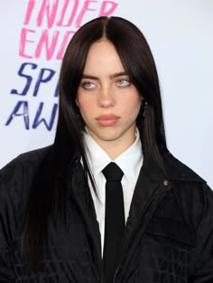 a woman with long hair wearing a black tie